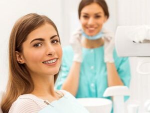 adult woman with braces smiling at doctors office