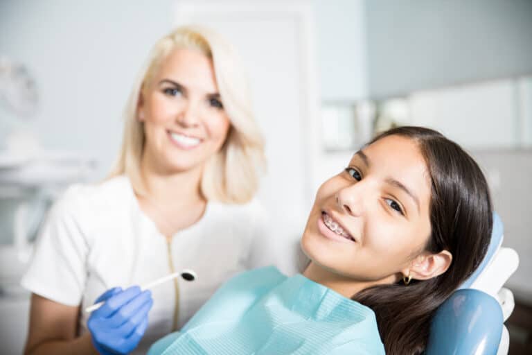 a young girl getting her braces inspected by an orthodontist