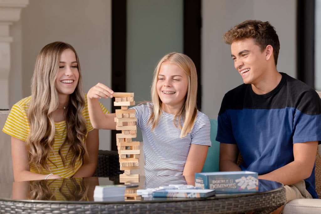 three smiling teens playing a game together